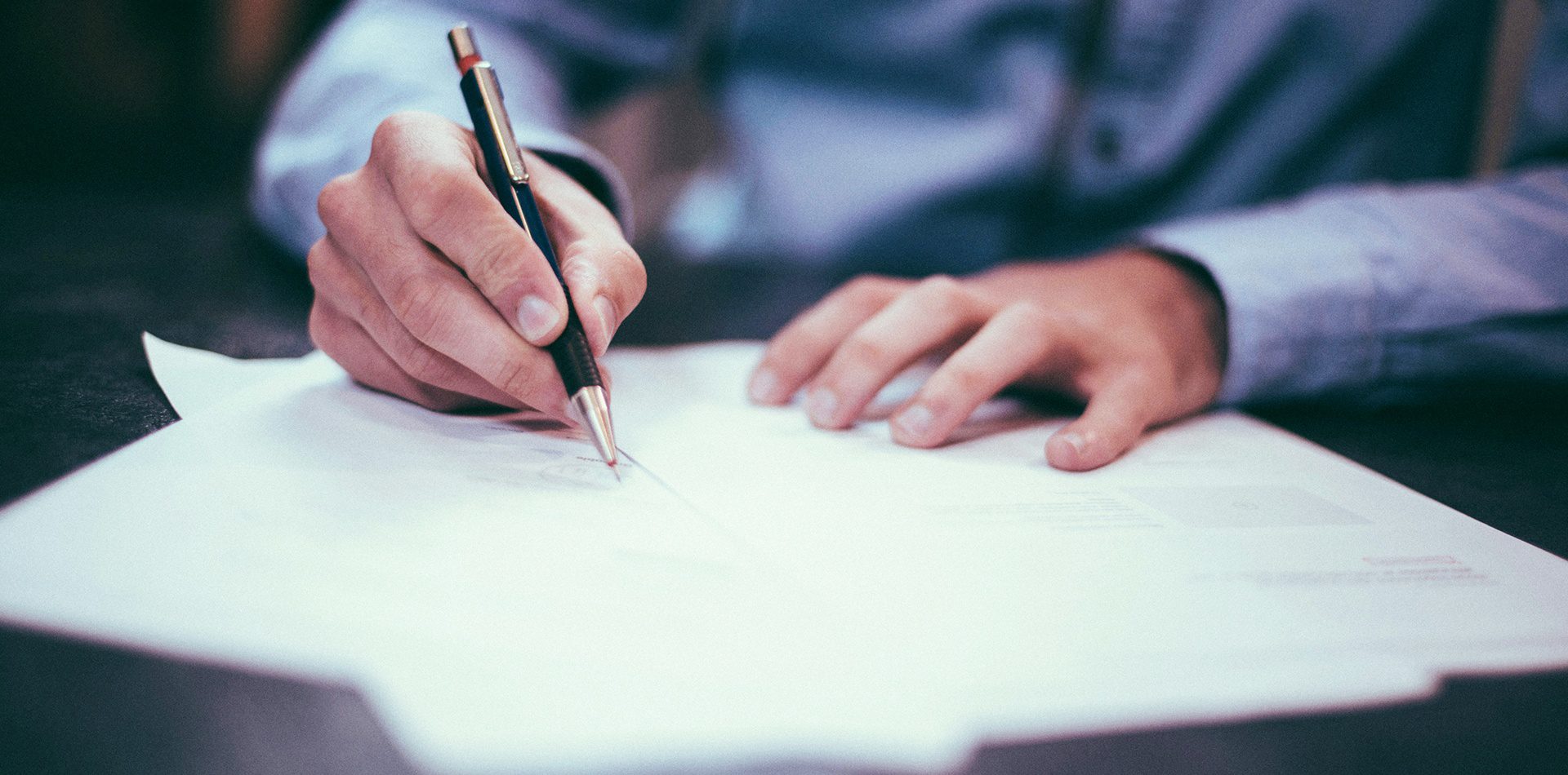 man writing on paper